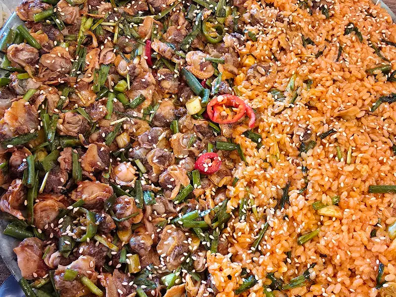 꼬막 비빔밥과 꼬막 무침이 반반씩 담겨 있는 쟁반의 클로즈업 사진