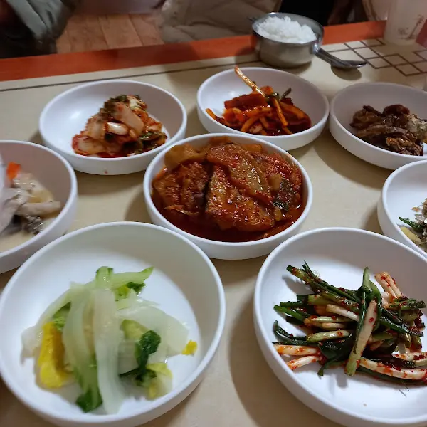 다채로운 반찬들이 테이블 가득 놓여 있는 모습