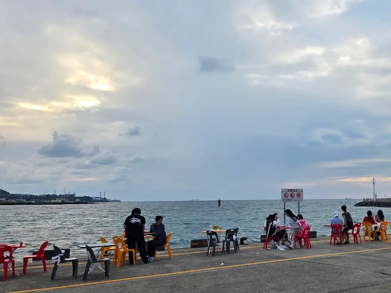 조천포구 방파제에 테이블을 놓고 앉아 회를 즐기는 사람들의 모습. 활기 넘치는 분위기가 인상적이다.