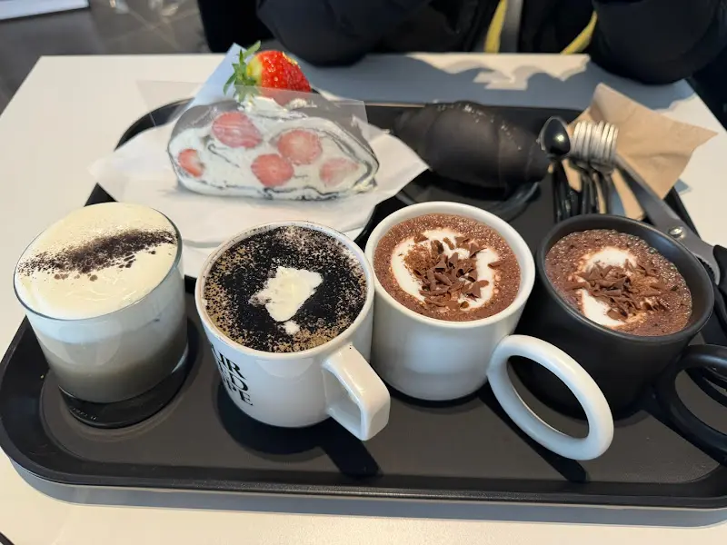 초코 크레페, 블랙 소금빵, 커피가 함께 담긴 트레이