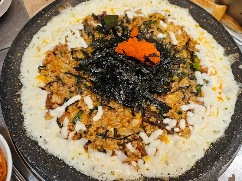 볶음밥 위에 치즈와 김가루, 날치알이 듬뿍 올려진 모습