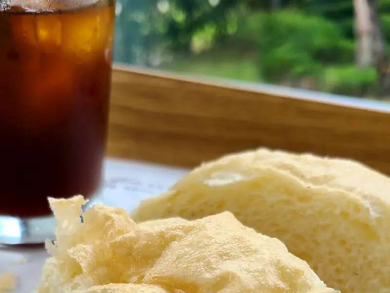 창가에서 보이는 풍경과 아이스 아메리카노, 치아바타 빵