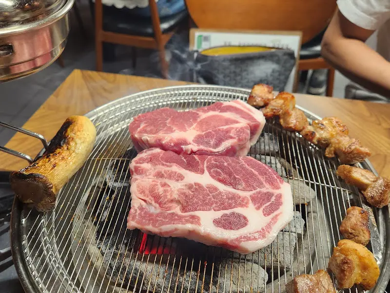 숯불 위에서 익어가는 두툼한 돼지고기