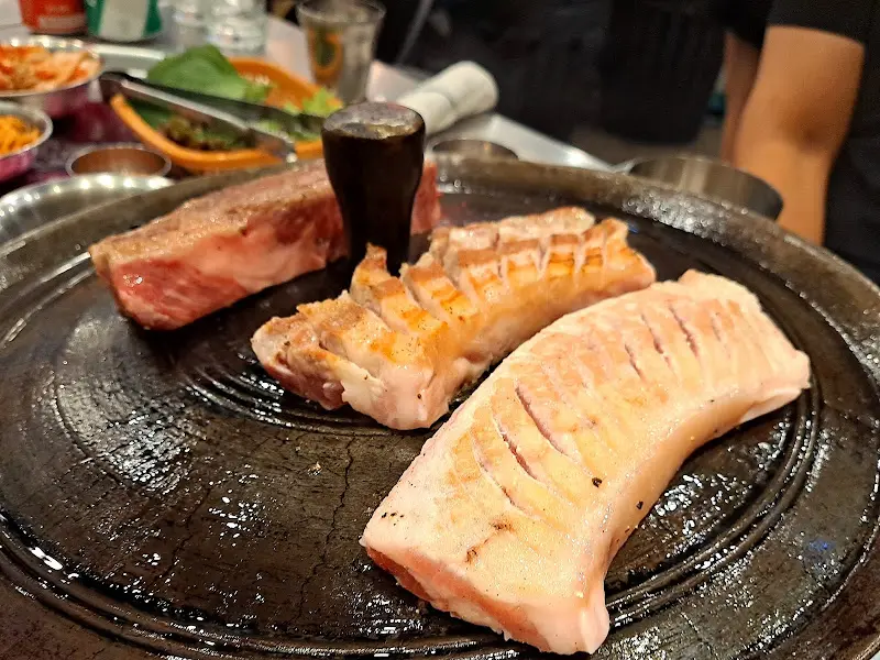 불판 위에 올려진 삼겹살, 목살, 본갈비살의 모습