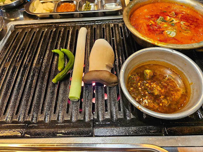 숯불 위에서 구워지고 있는 고기와 채소