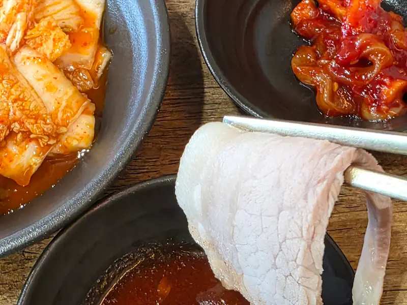 젓가락으로 수육을 집어 올리는 모습