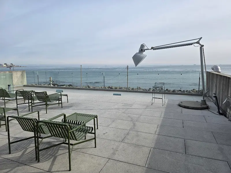 바다를 배경으로 놓인 야외 테이블과 의자