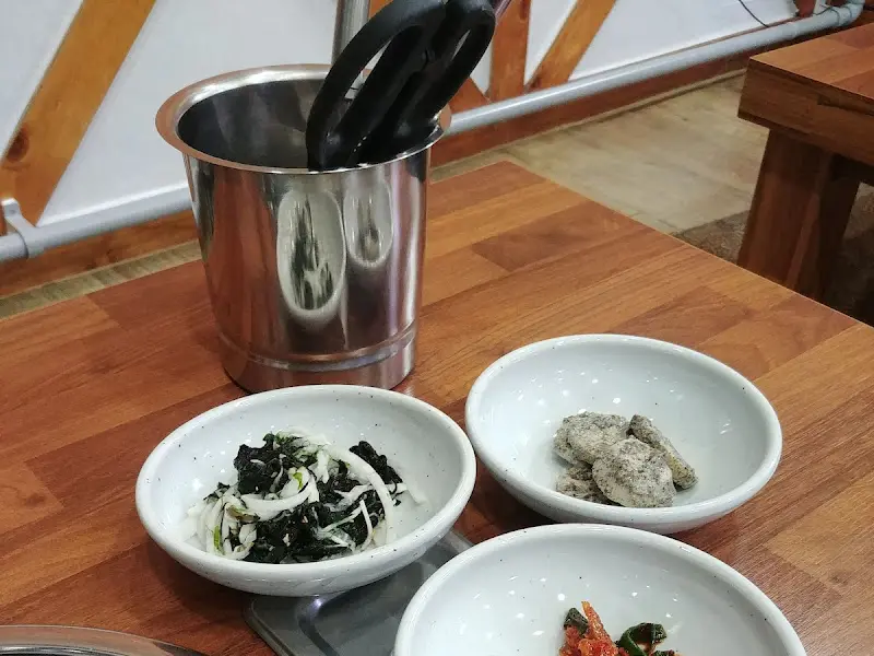 테이블 위에 놓인 반찬 그릇과 집게