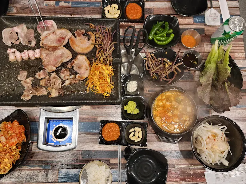 테이블 가득 차려진 돼지갈비와 다양한 곁들임 메뉴들