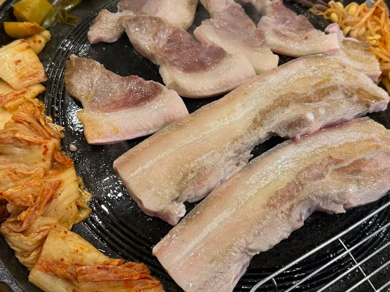 불판 위에 올려진 삼겹살과 김치