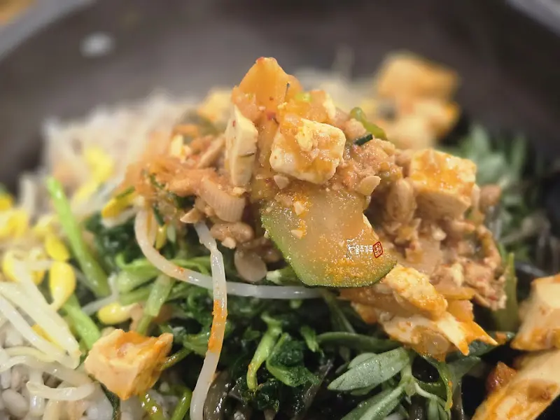 청국장과 각종 나물을 넣고 비빈 보리밥 비빔밥의 클로즈업 사진