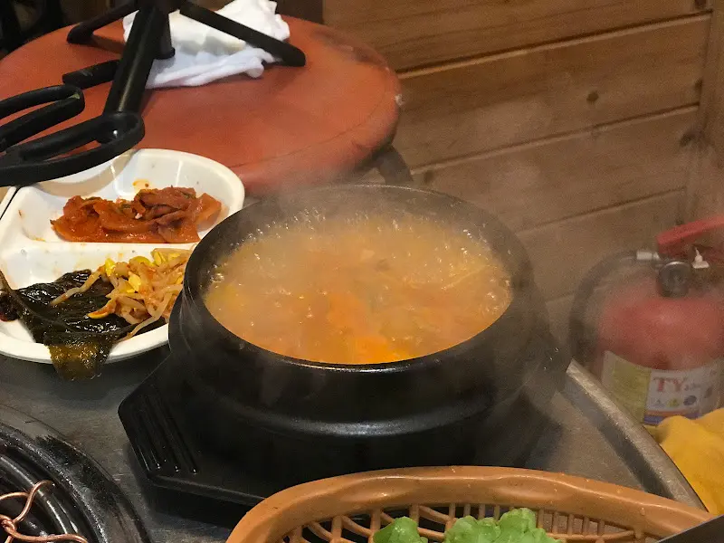 불판 옆에 소주병과 반찬 그릇이 놓여있는 모습