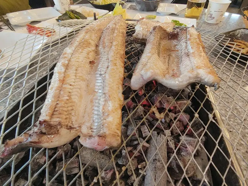 숯불 위에서 노릇하게 구워지고 있는 큼지막한 장어