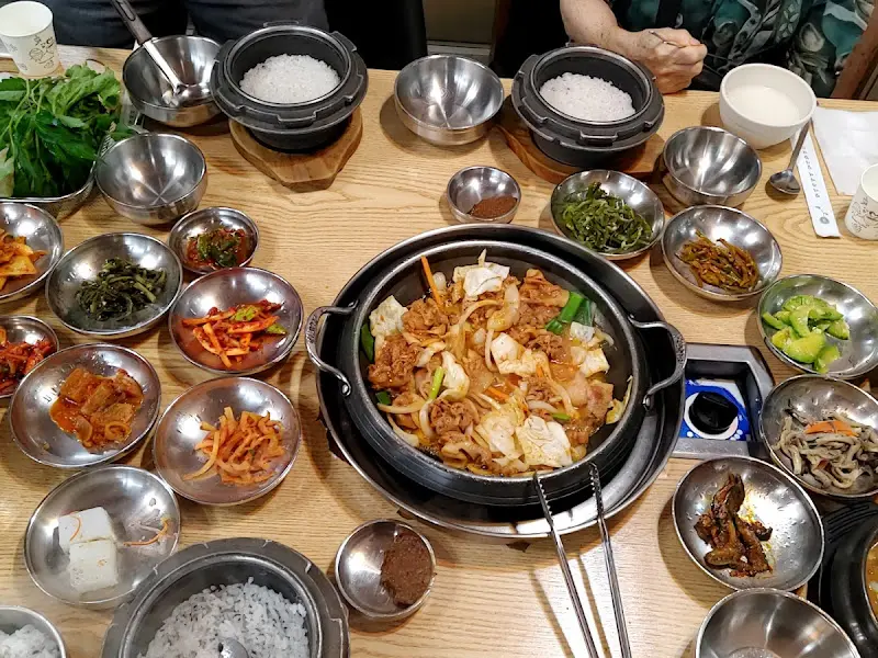 돌솥밥과 쌈 채소, 다양한 반찬이 차려진 쌈밥 한 상