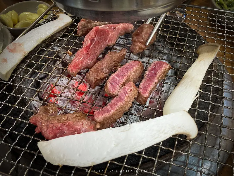 숯불 위에서 익어가는 한우 갈비살과 새송이버섯