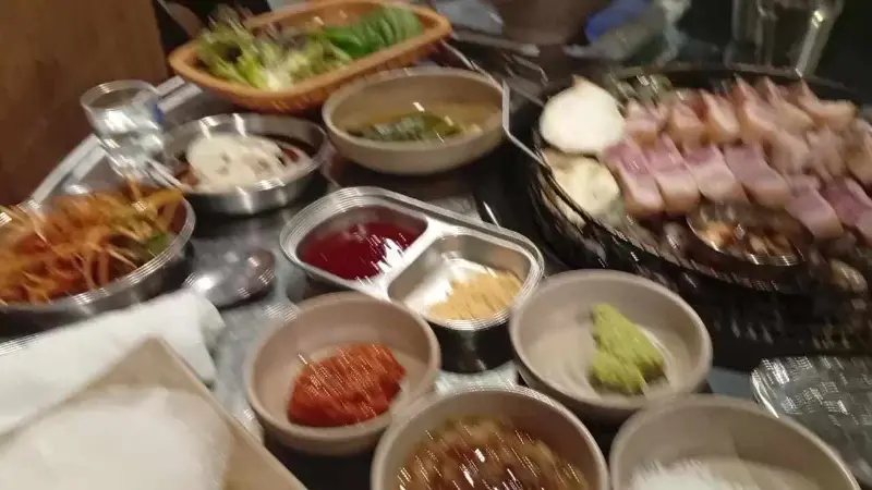 다양한 곁들임 메뉴와 구워지는 고기