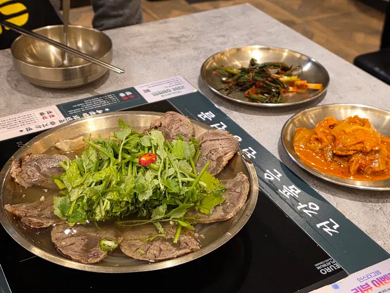 수육전골, 김치, 미나리전이 차려진 테이블 전경