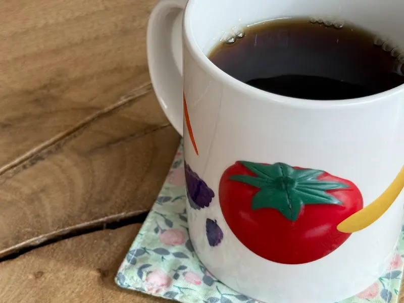 토마토 그림이 그려진 컵에 담긴 따뜻한 차