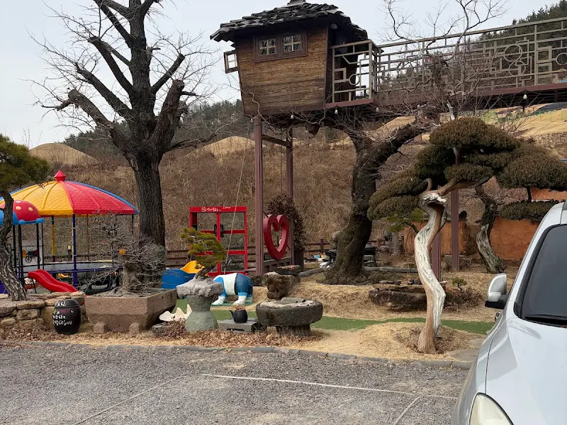 아이들을 위한 놀이 공간과 작은 오두막이 있는 카페 외부 전경