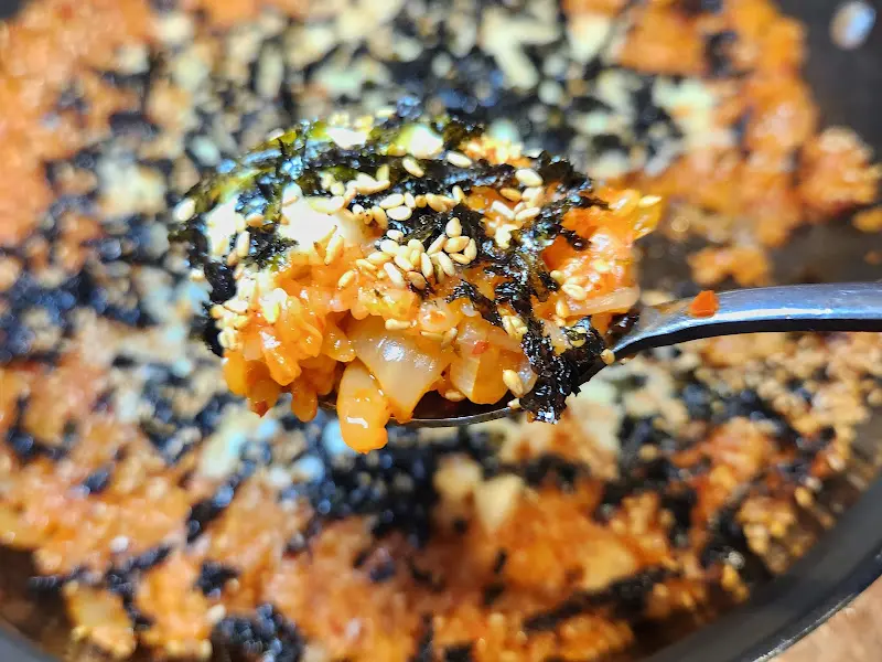 김가루와 깨가 뿌려진 김치치즈볶음밥