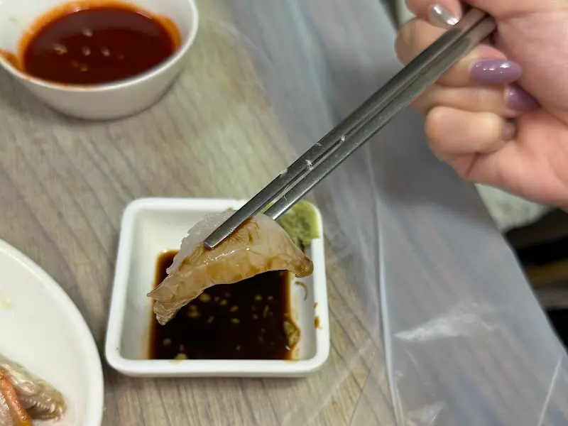 젓가락으로 집어 올린 뽀얀 회 한 점