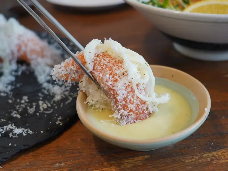 눈꽃 연어 초밥을 소스에 찍는 모습