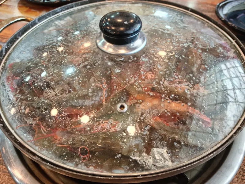 뚜껑 덮인 냄비 안에서 익어가는 새우들