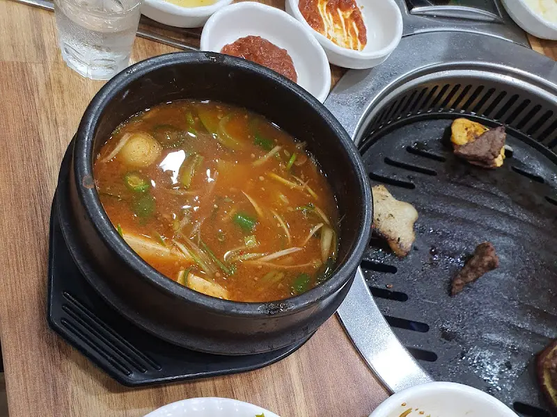 고기가 구워지는 불판 옆에 놓인 뚝배기