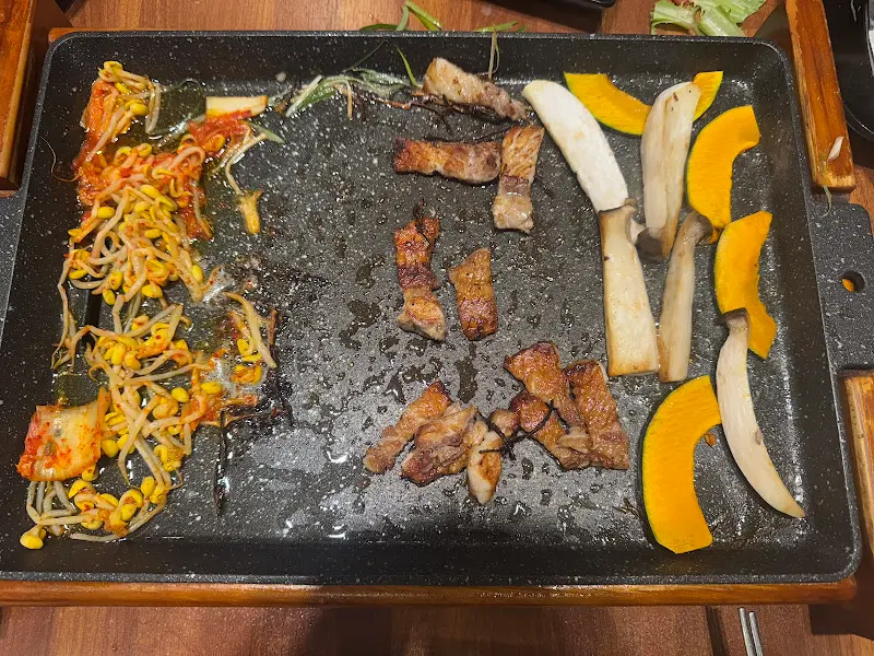 불판 위의 삼겹살과 김치, 콩나물