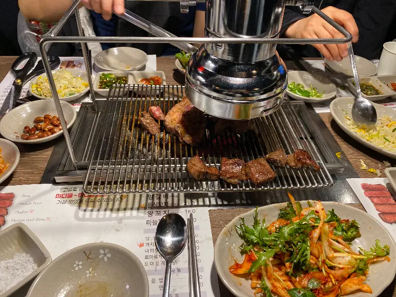 숯불 위에서 구워지고 있는 양꼬치의 모습