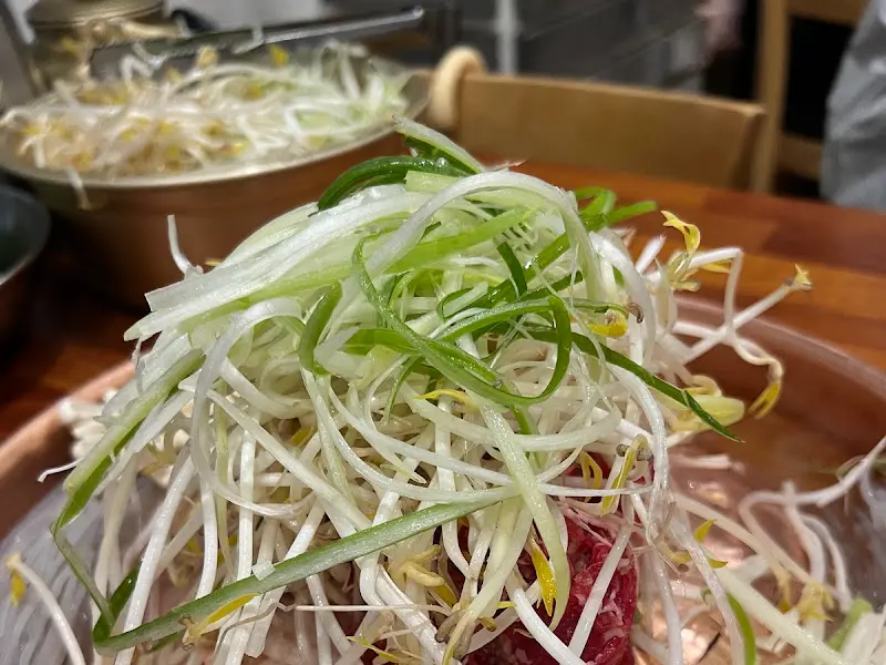 불고기 위에 숙주와 파가 가득 쌓여있는 모습