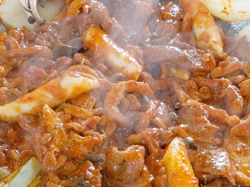 돌판 위에 구워지는 오리고기와 떡