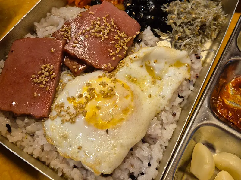 옛날 도시락에 담긴 계란후라이와 분홍 소시지의 조화