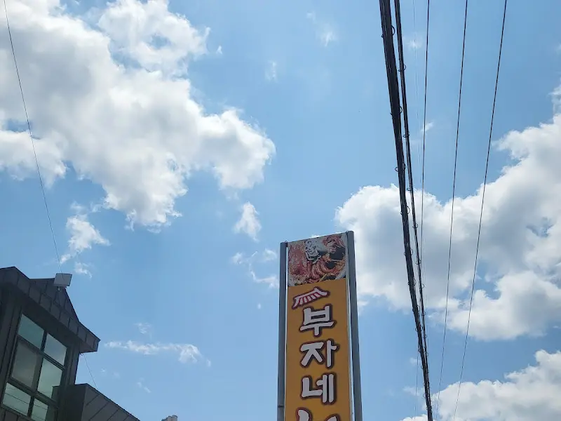 파란 하늘 아래 우뚝 솟은 부자네 해물찜 간판
