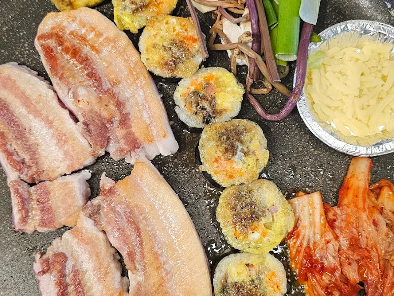 김치와 고사리, 버섯 등 다채로운 곁들임이 구워지고 있는 모습