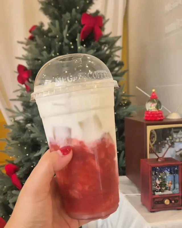 크리스마스 트리 옆에서 딸기라떼를 들고 있는 모습