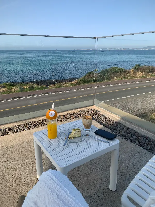 테라스 테이블 위에 놓인 한라봉 쥬스와 바스크 치즈케이크