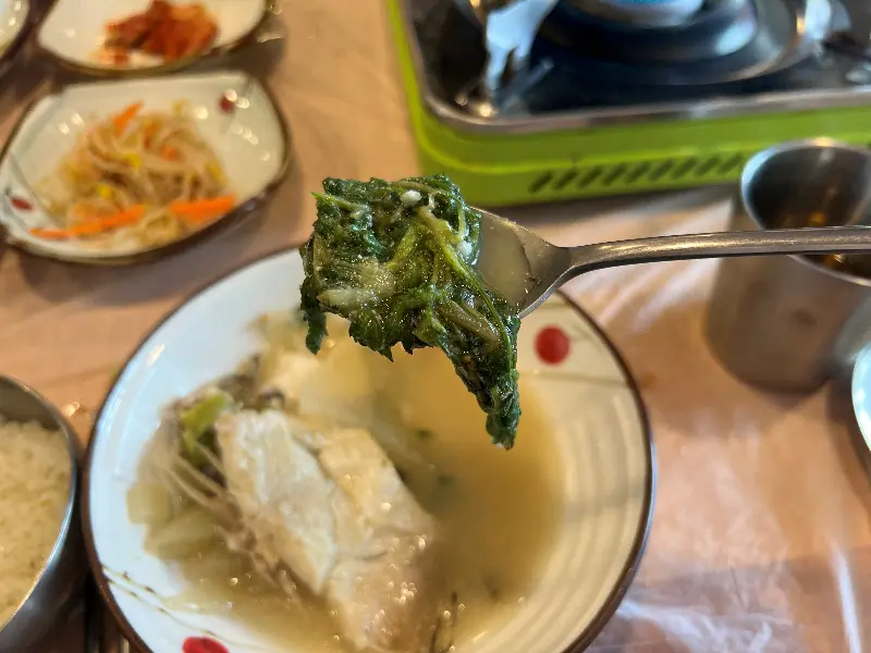 숟가락 위에 올려진 도다리와 쑥