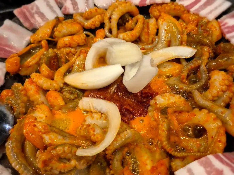 불판 위에서 익어가는 쭈꾸미 삼겹살의 클로즈업