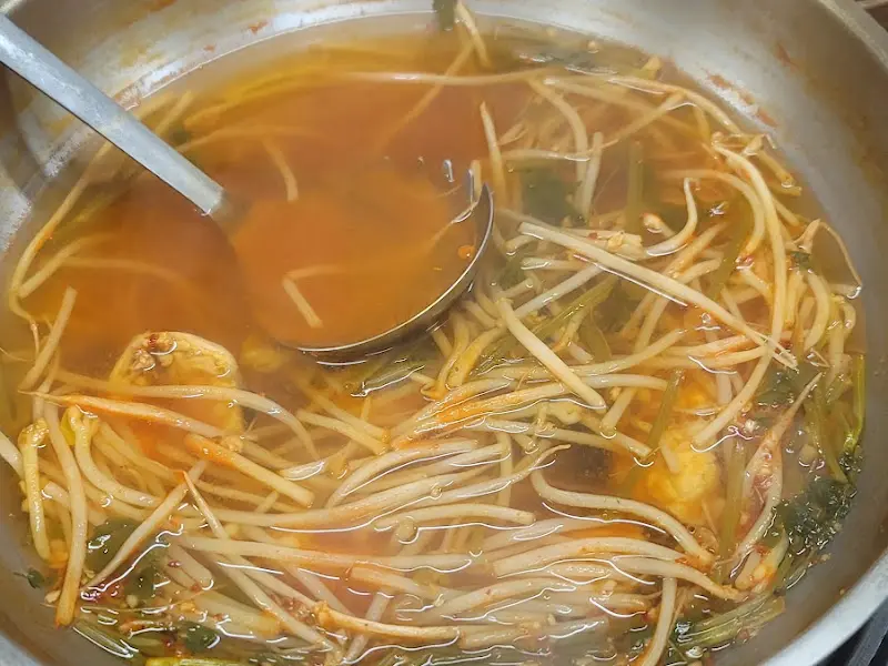 국자로 탕 국물을 뜨는 모습