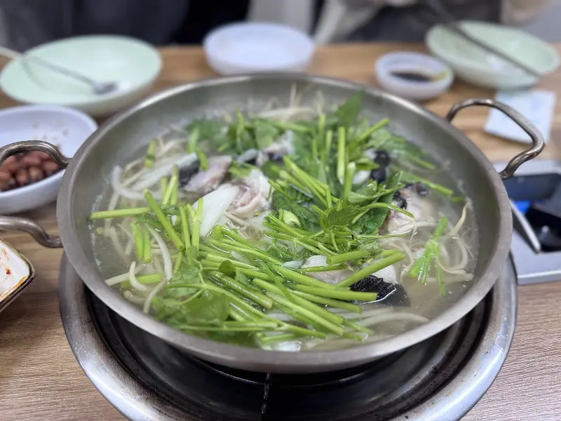 테이블 위에서 끓고 있는 복어탕 전체 샷