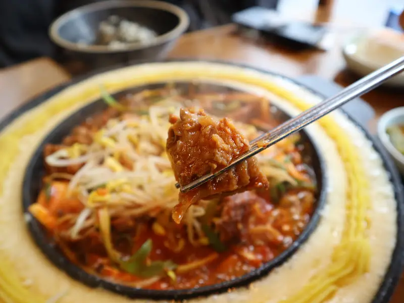 갈비찜을 젓가락으로 집어 올리는 모습