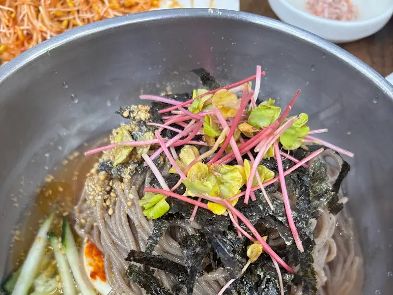 메밀면 위 김가루와 메밀싹 고명