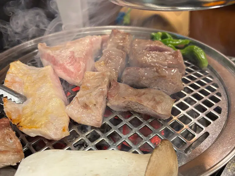 불판 위에 올려진 삼겹살과 버섯, 고추