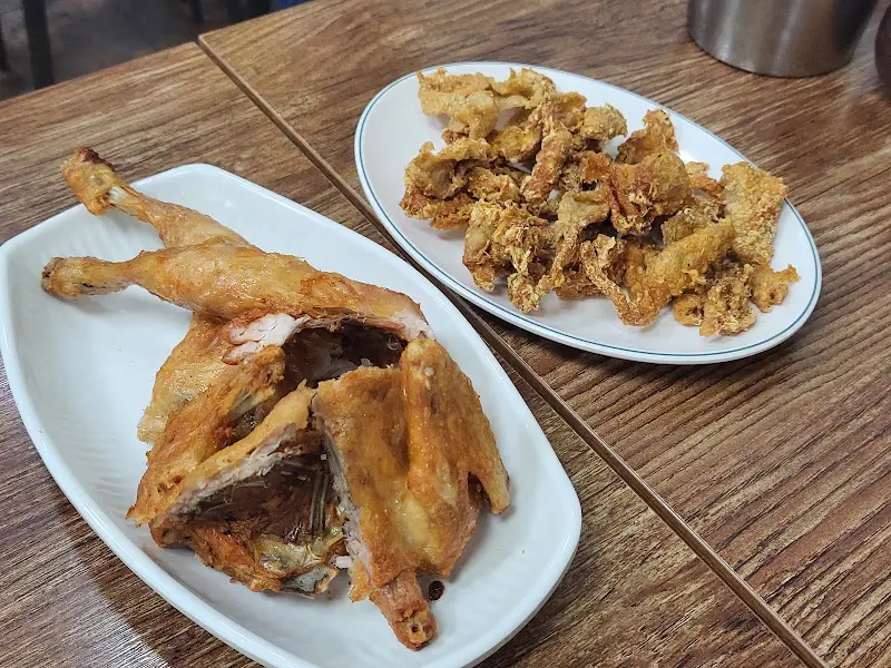 테이블 위에 놓인 옛날 통닭 한 마리와 닭똥집 튀김