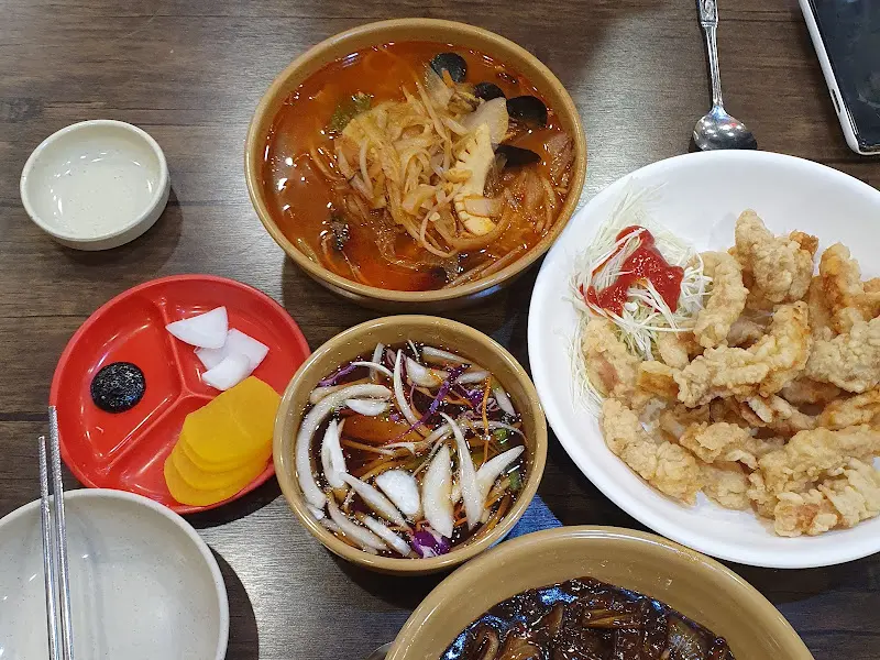 테이블에 놓인 짜장면, 짬뽕, 탕수육