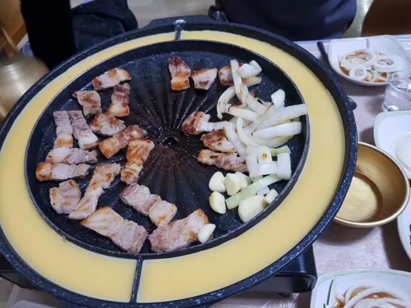 불판 위의 돼지고기와 양파, 마늘