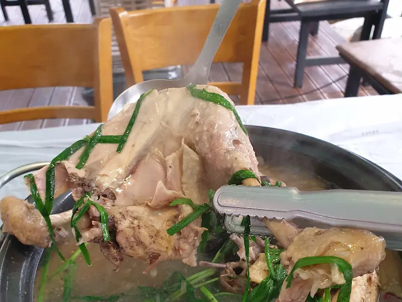 닭백숙을 집게로 들어올리는 모습