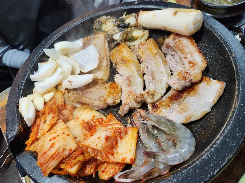 불판 위에 익어가는 삼겹살과 해산물