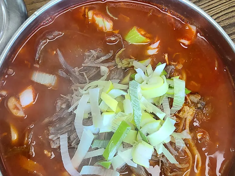 다진 마늘과 양념이 녹아든 육개장 칼국수 국물